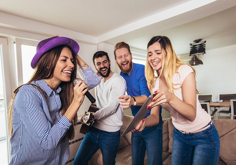 Group of friends playing karaoke at home. Concept about friendship, home entertainment and people